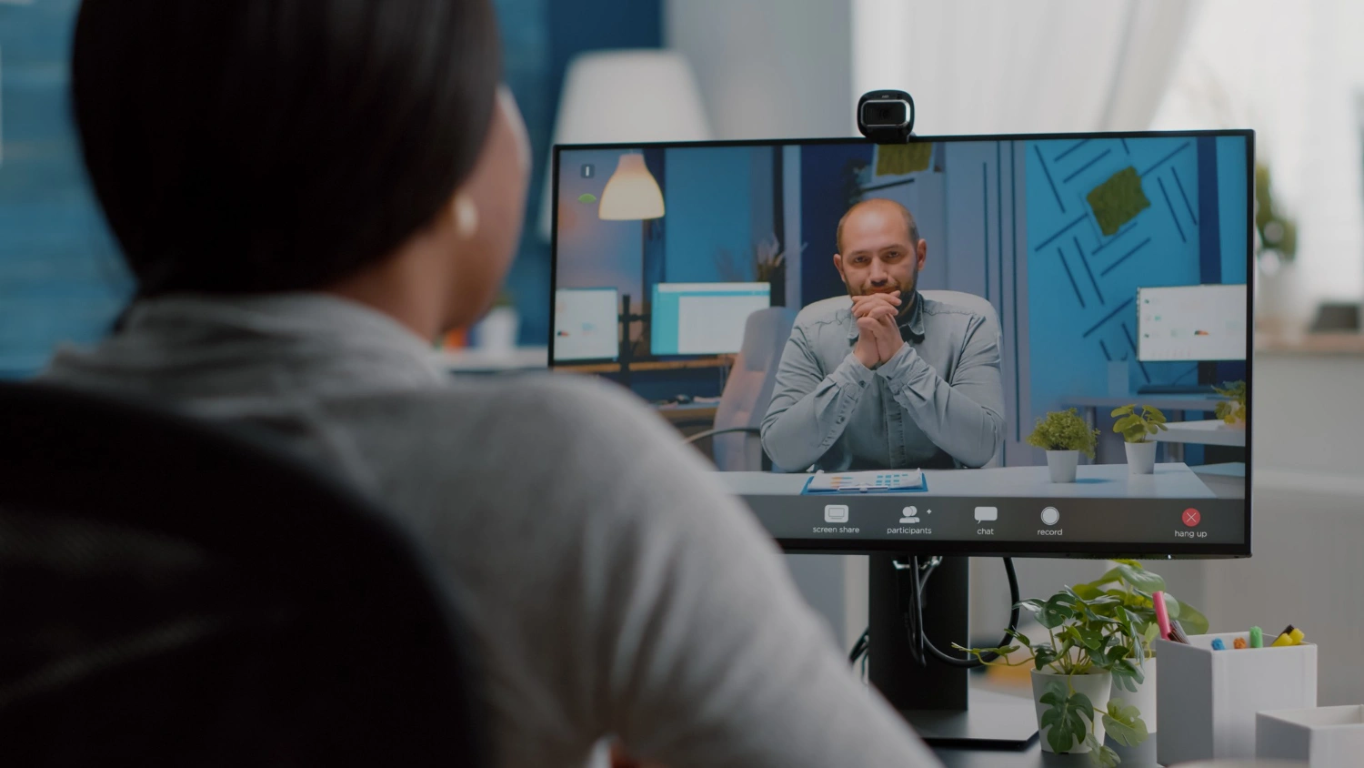 A woman on an AxxHD video call at her desk